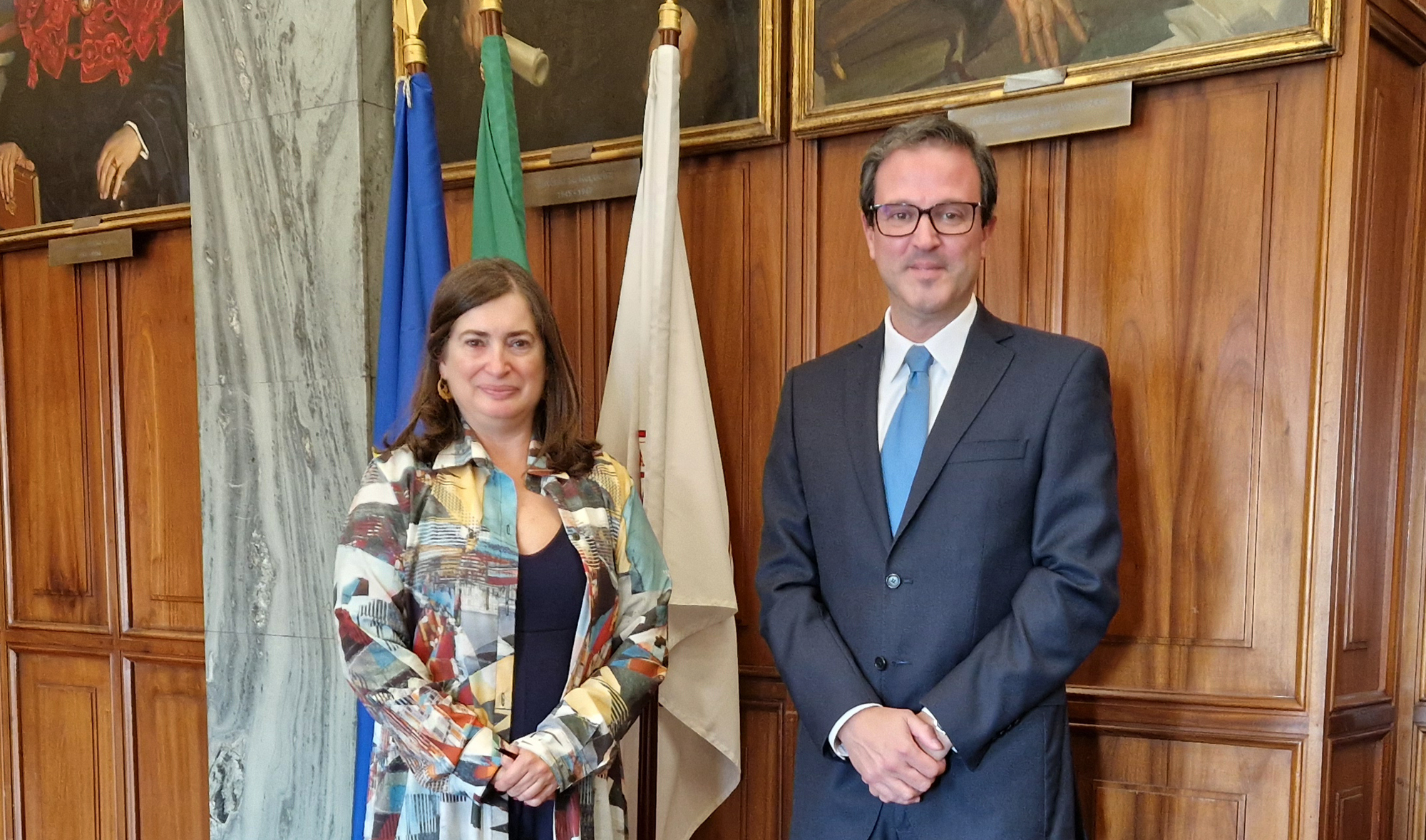 In the image is visible two people posing for a photograph, namely, Fernanda de Almeida Pinheiro - President of the Bar Association and. on his right side, Rodrigo Ramos - President of the INR. Behind them are (partly) flags and paintings.