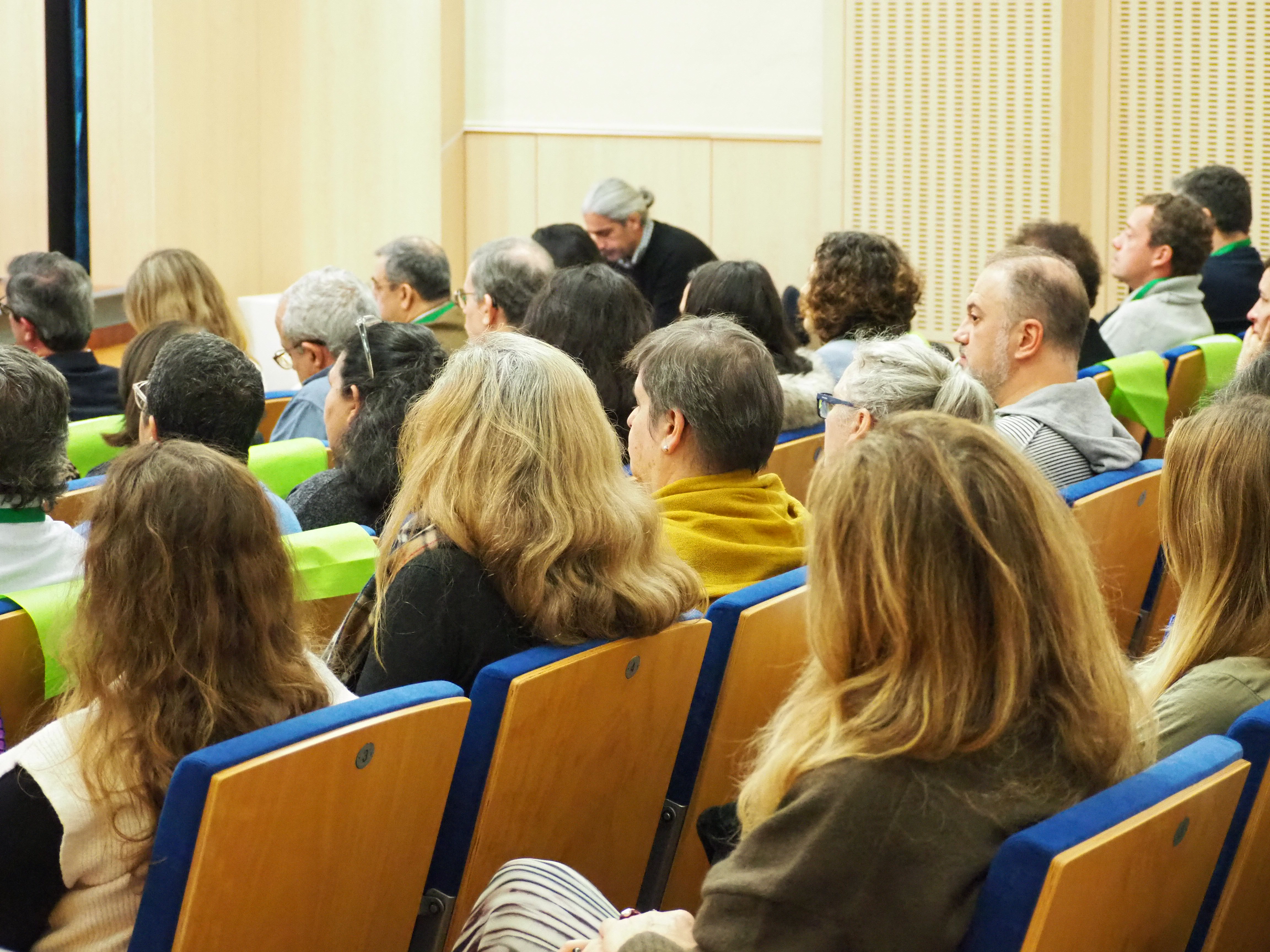  É visível várias pessoas sentadas, a assistir ao evento. 