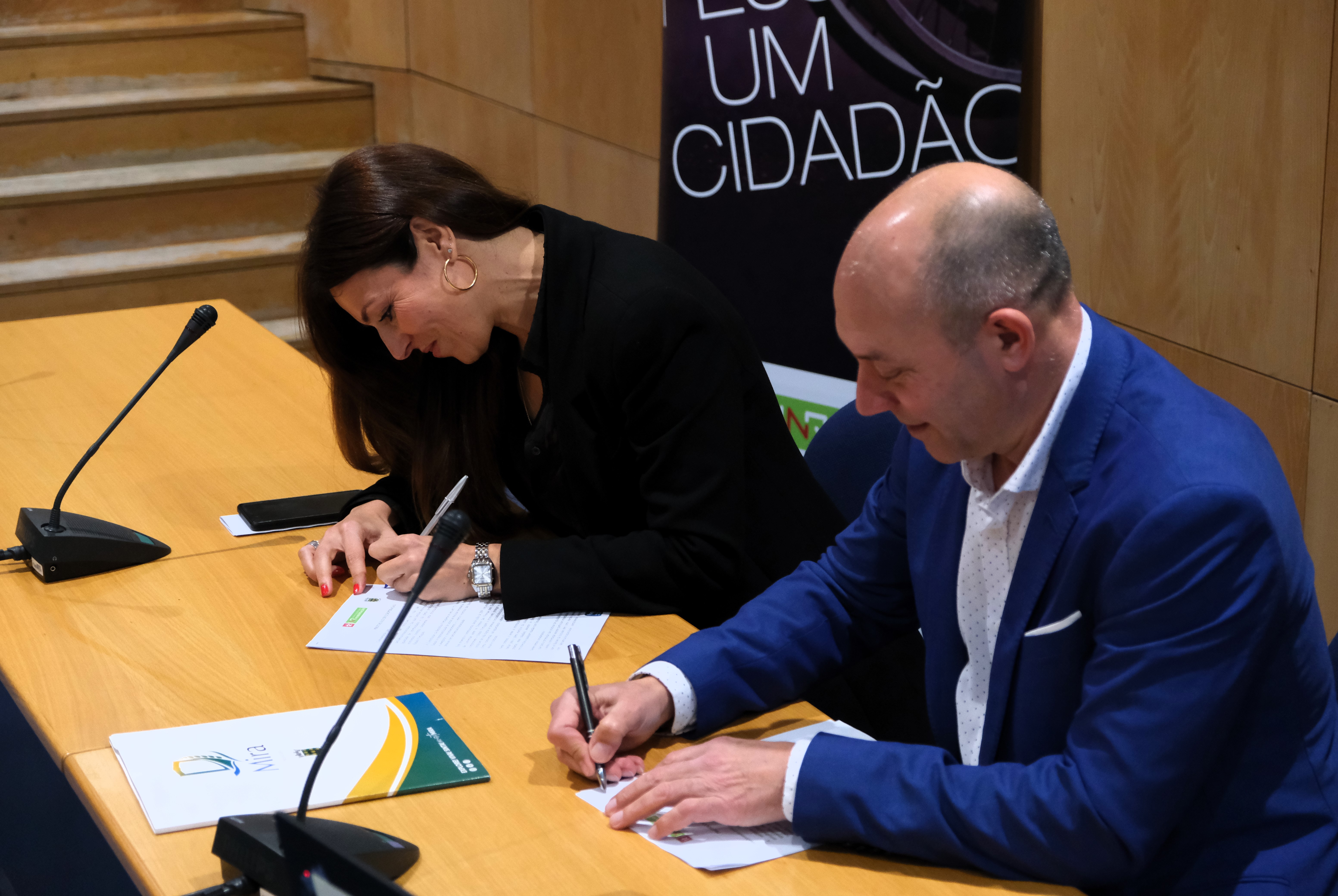  Sónia Esperto (INR) e Artur Fresco (CM de Mira) sentados, a assinar as folhas do protocolo. 