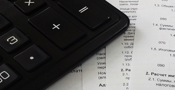 Black calculator on paper with numbers.