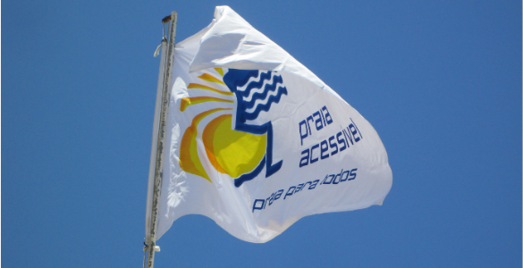 Fotografia de uma bandeira do Programa “Praia Acessível – Praia para Todos!”