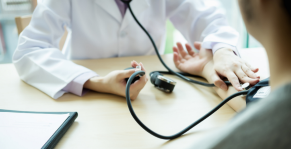 Uma médica mede a tensão arterial a um paciente