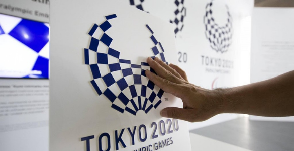 Fotografia de uma mão de uma pessoa a tocar no logotipo dos Jogos Paralímpicos em relevo