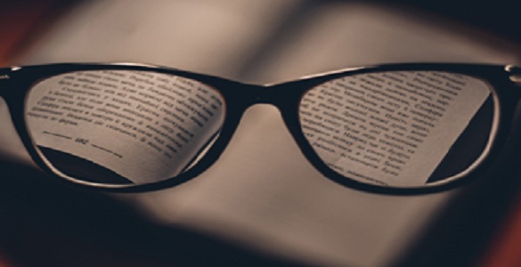 óculos sobre um livro aberto.
