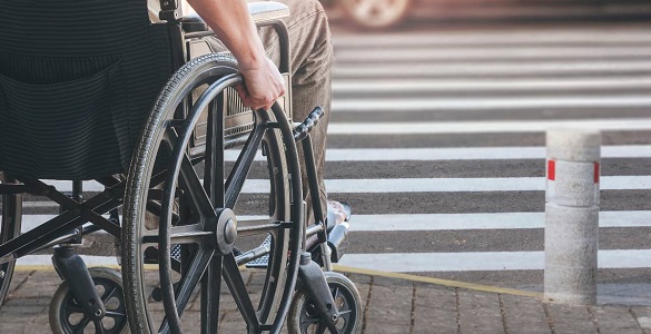  Homem sentado numa cadeira de rodas de frente para um lanço de escadas 